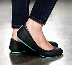 Close up of a woman wearing Matte Black Tieks leather ballet flat shoes.